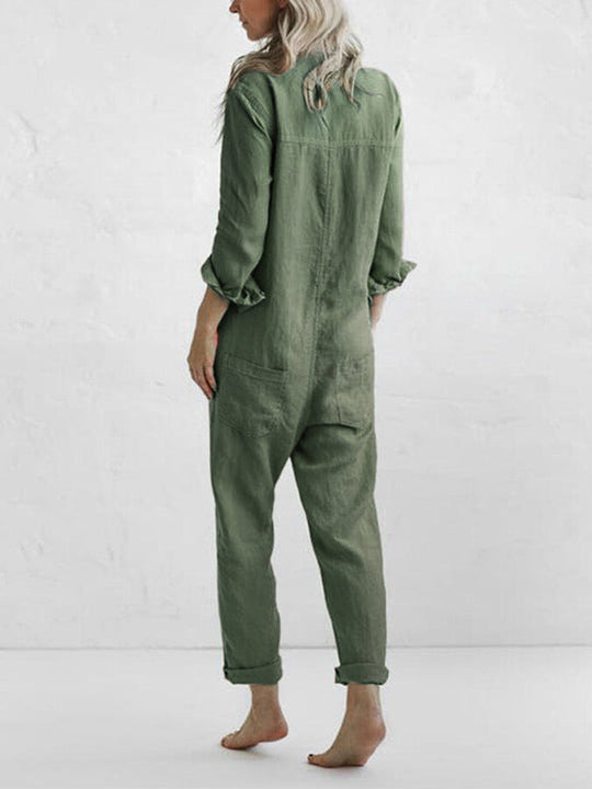 Comfortabele groene katoenen jumpsuit met lange mouwen, gedragen door een persoon met lang blond haar, gezien vanaf de achterkant. De jumpsuit heeft een losse pasvorm en zakken aan de achterzijde.