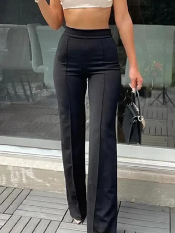 Elegante zwarte flared broek met hoge taille, accentueert vrouwelijke vormen en verlengt silhouet. Gedragen met witte crop top en zwarte handtas voor een stijlvolle look. Perfecte combinatie van comfort en mode voor diverse gelegenheden. Trendi Mode